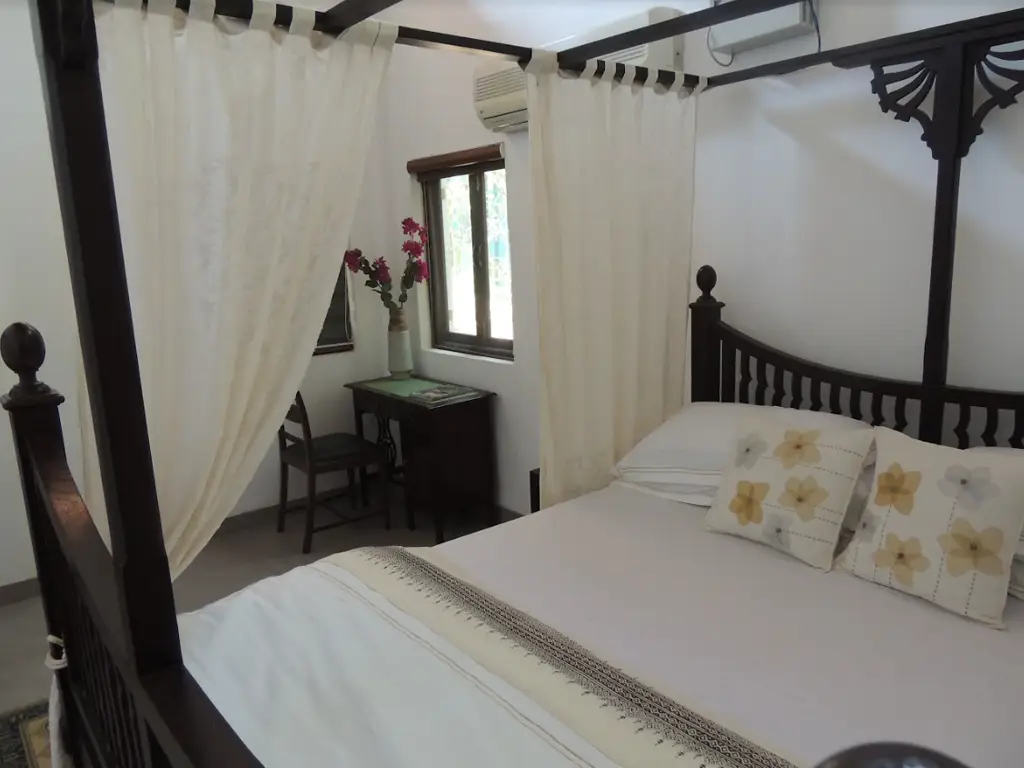 Luxury bedroom with four poster bed at Casa Mango villa in Alibaug